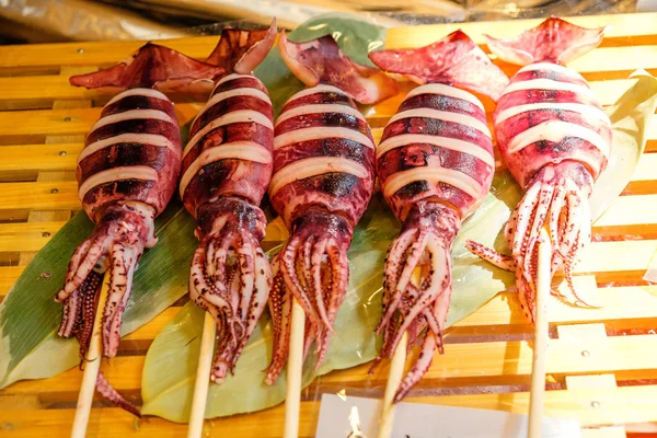 Grillad bläckfisk på pinne på Tsukiji Market, Tokyo Royaltyfria Stockfoton