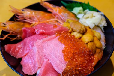 Suşi pilavı ile servis edilen çeşitli deniz ürünleri.