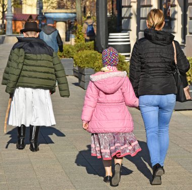 Anne ve iki çocuğu sokakta yürüme