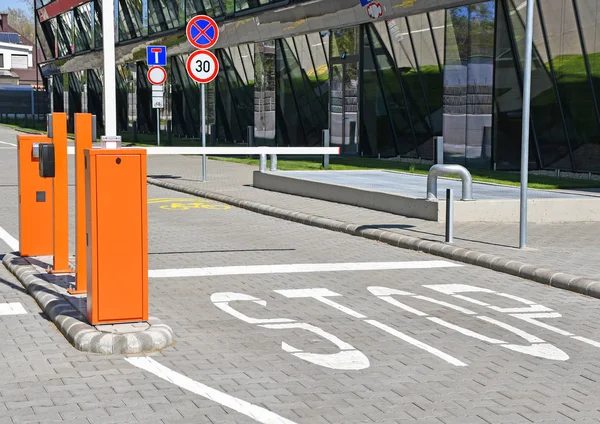 Parkplatztor und Stoppschild neben einem Bürogebäude — Stockfoto