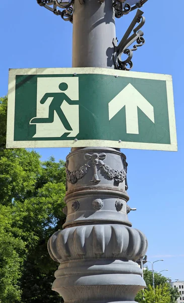 Exit sign on an ornate metal pole on the street