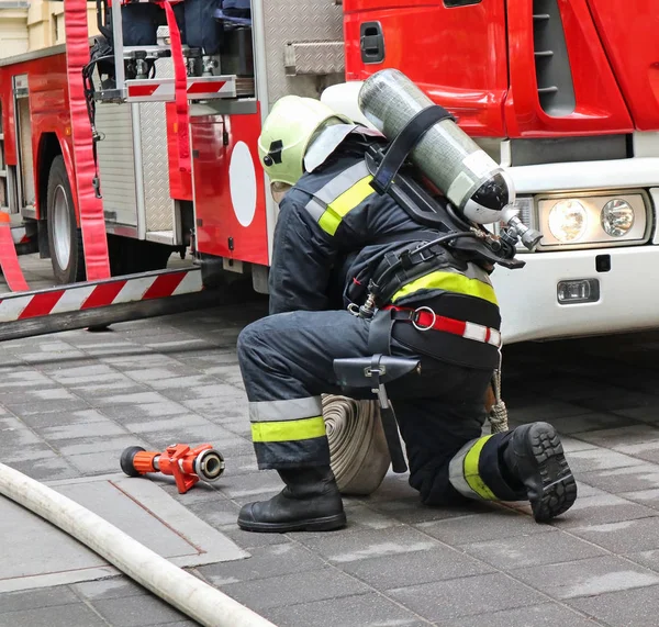 Firefighter works next to a firetruck — Stock Photo, Image