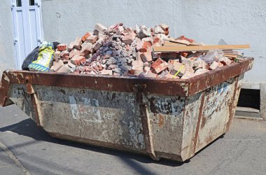 Endüstriyel çöp tenekesi inşaat malzemeleriyle dolu