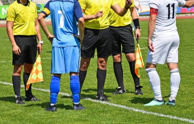 Soccer players and referees before match clipart