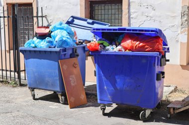 Eski bir sanayi binasının arka bahçesindeçöp tenekeleri