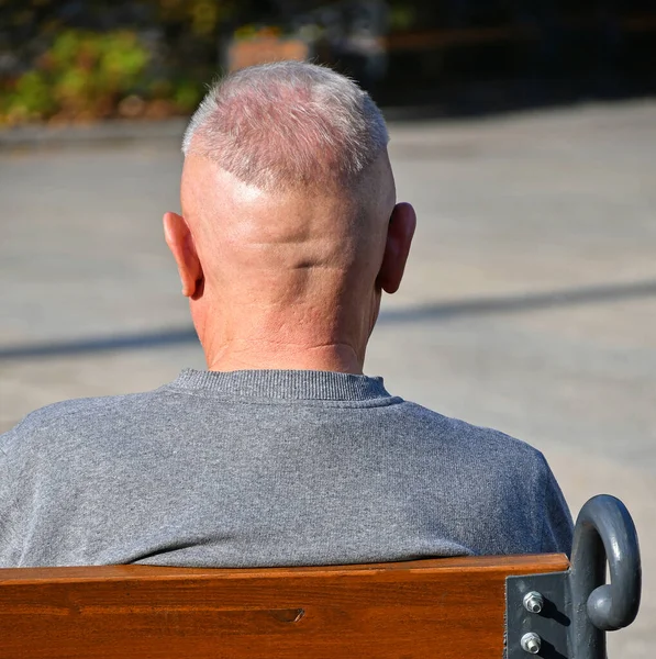 老人は公園のベンチに座っている。 — ストック写真