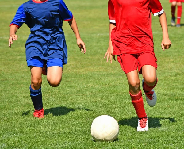 Barnen spelar fotboll utomhus på sommaren — Stockfoto