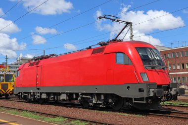 Raylarda kırmızı tren motoru var.