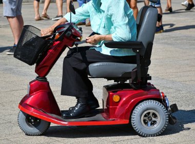 Elektrikli sandalyesi olan engelli yaşlı bir kadın.