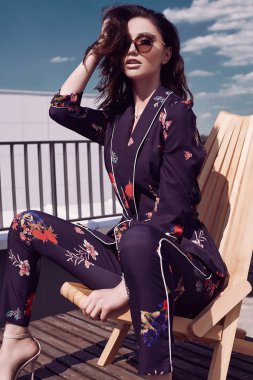 Bir binanın çatı bir tahta sandalyede oturan canlı içinde muhteşem bir parlak esmer kadın portresi