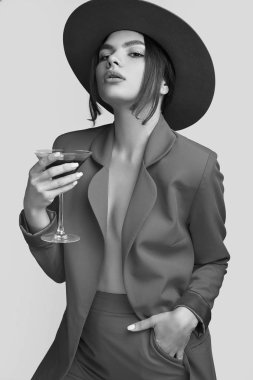 Bir kırmızı moda bir takim elbisesi ve Studio beyaz arka plan üzerinde izole geniş alkolle kokteyl zarif güzel kadın portresi