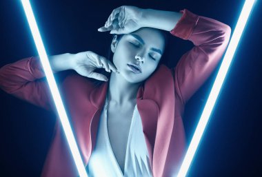 Parlak neon ışıkları poz kırmızı şık elbiseli şık güzel kadın portresi