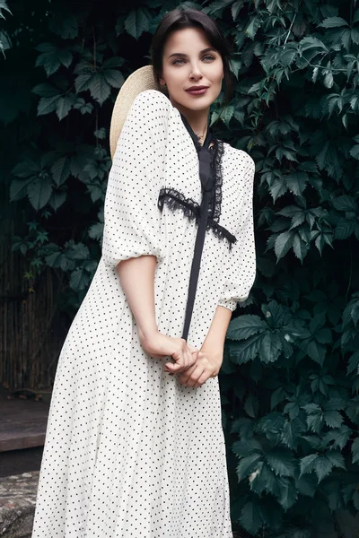 Hasır şapka bahçede poz ile moda içinde muhteşem bir parlak esmer kadın portresi