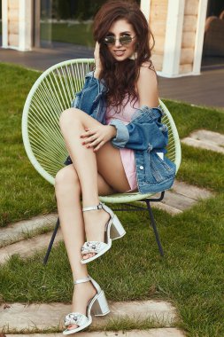 Esmer güzel şehvetli bahçede poz moda pembe elbise ve kot ceket modelinde portresi