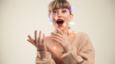 Güzel sarışın kadının kafasına Noel ışıkları ile moda parlak portre. Stüdyo çekimi.