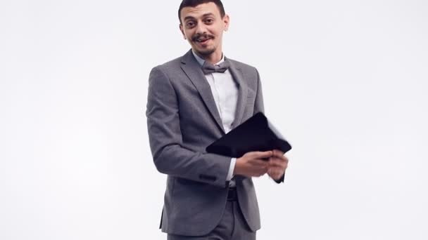 灰色スーツ白スタジオの背景に分離されたタブレットを保持で派手な口髭のハンサムな若い自信アラビア語ビジネスマンの肖像画 — ストック動画