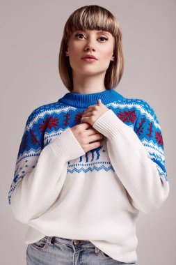 Noel kazağı kısa saçlı güzel sarışın kadın portresi. Stüdyo çekimi.