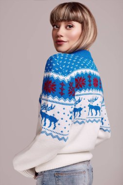 Noel kazağı kısa saçlı güzel sarışın kadın portresi. Stüdyo çekimi.