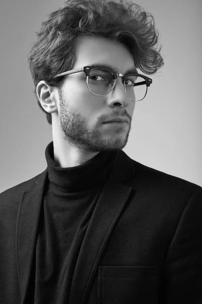 スタジオで背景が灰色のスーツと眼鏡を着て巻き毛を持つハンサムなエレガントな男のファッション ポートレート — ストック写真