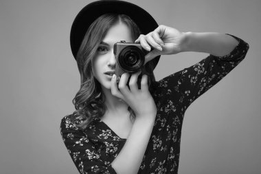 Şehvetli şık sihir hippi kız kırmızı moda elbise, siyah şapka ve gözlük Studio pembe renkli arka plan üzerinde kamera ile poz portresi