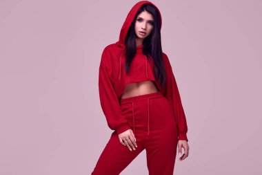Moda kırmızı hoodie studio arka plan üzerinde poz güzel esmer kadın portresi
