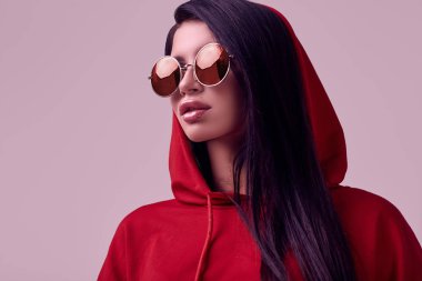 Moda kırmızı hoodie studio arka plan üzerinde poz güzel esmer kadın portresi