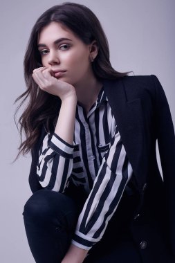 Bir şeritli bluz ve siyah ceket Studio beyaz arka plan üzerinde izole giyen moda esmer kadın portresi