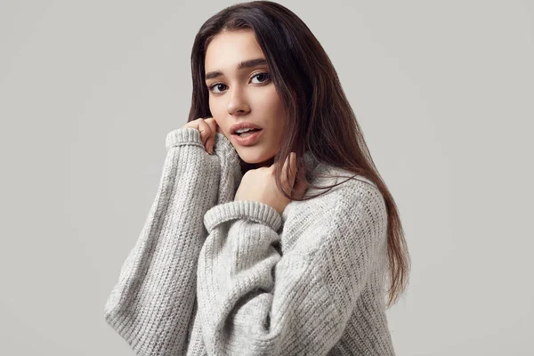 Beautiful brunette woman in sweater posing in studio — Stock Photo, Image