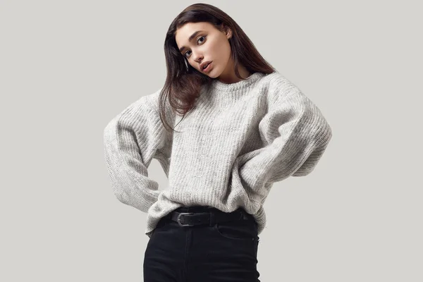 Красива брюнетка в светрі позує в студії — стокове фото