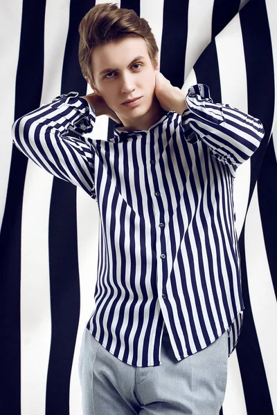 Fiatal jóképű férfi csíkos ing pózol fekete-fehér háttér — Stock Fotó