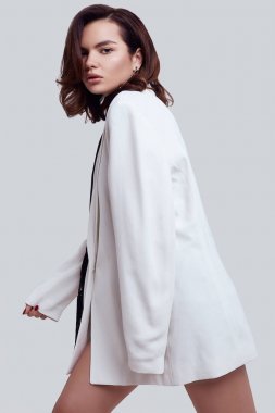 Moda beyaz takım elbise koyu saçlı çekici zarif kadın