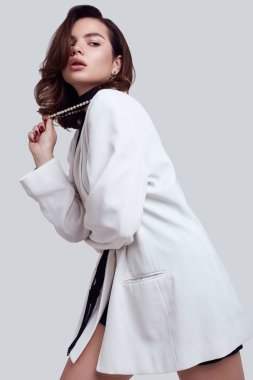 Moda beyaz takım elbise koyu saçlı çekici zarif kadın