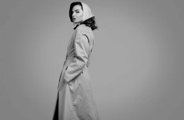 Young elegant brunette woman in coat and shawl posing in studio — 스톡 사진