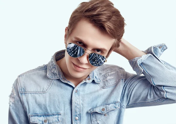 Hombre hipster guapo en gafas de sol de moda con chaqueta vaqueros —  Fotos de Stock
