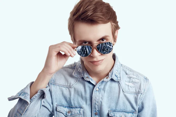 Hombre hipster guapo en gafas de sol de moda con chaqueta vaqueros —  Fotos de Stock