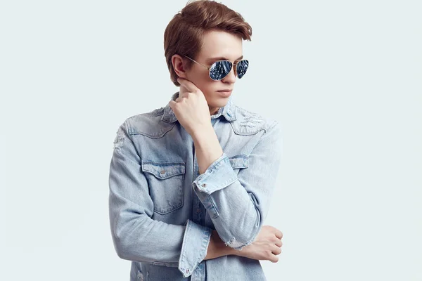 Bonito hipster homem de moda óculos de sol usando jaqueta de jeans — Fotografia de Stock
