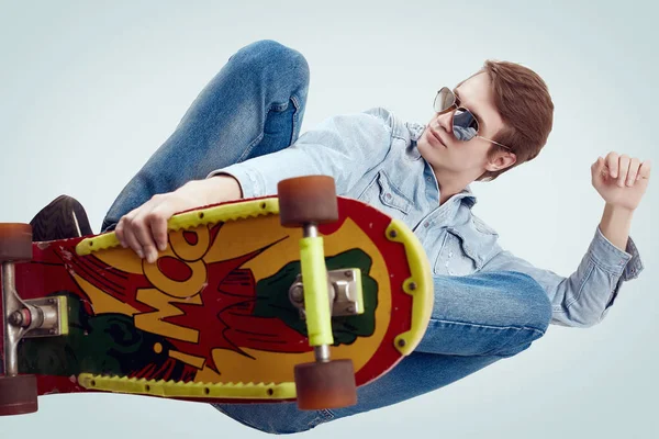 Şık kaykay üzerinde flip yapıyor kot ceket yakışıklı hipster adam