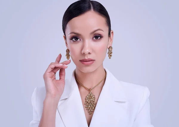 Nádherná Latinská žena v módním bílém obleku, který nosí drahé šperky — Stock fotografie