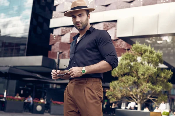 Beautiful brutal tanned muscular hipster man posing in the streets — Stock Photo, Image