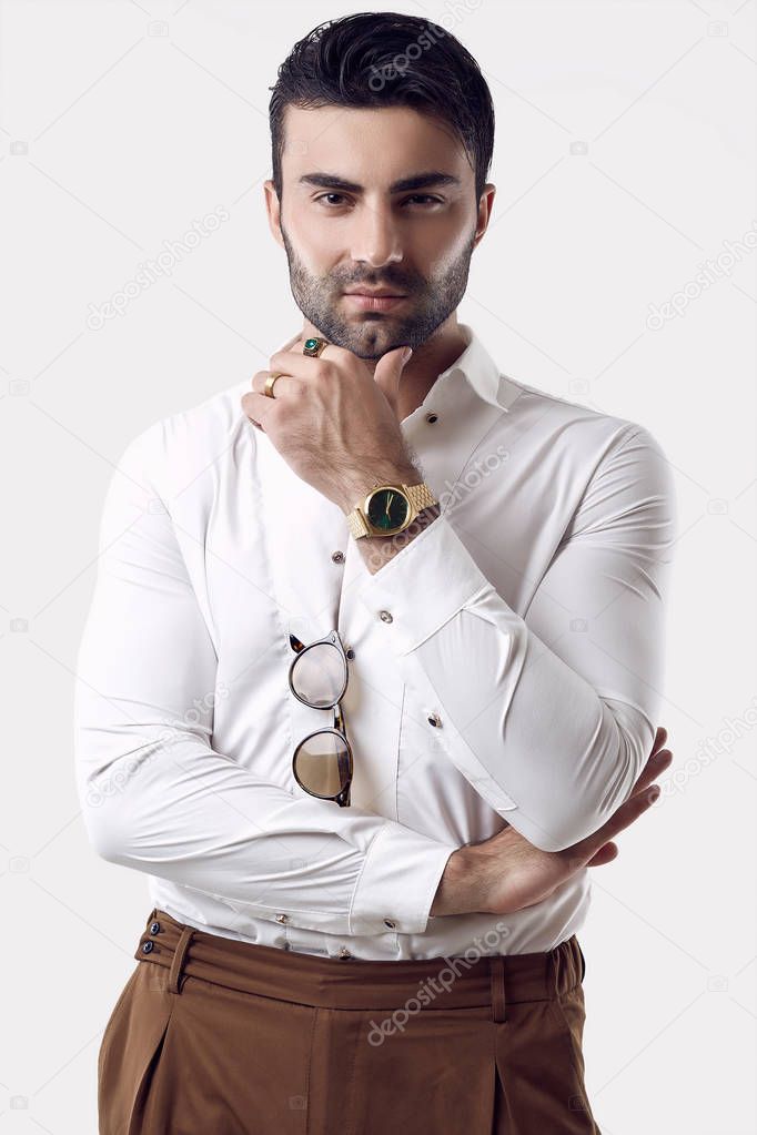 Beautiful brutal tanned businessman in a white shirt and sunglasses
