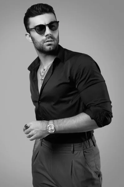 Bonito brutal bronzeado hipster homem em uma camisa preta e óculos — Fotografia de Stock