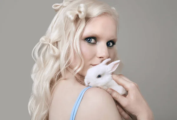 Блондинка Альбинос в элегантном платье позирует с милым маленьким кроликом — стоковое фото