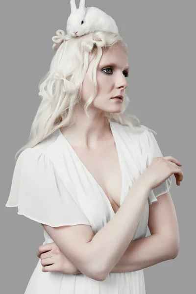 Albino szőke lány elegáns ruhában jelentő aranyos kis nyúl — Stock Fotó