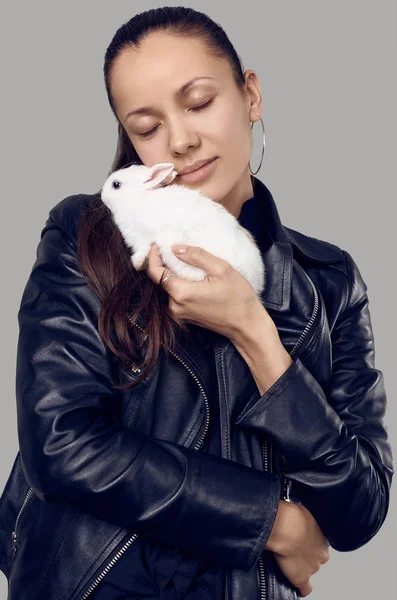 Gorgeous latin women in fashion leather jaket with cute little rabbit