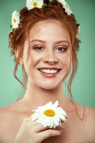 Hermosa chica pelirroja positiva con una corona de manzanilla en la cabeza — Foto de Stock