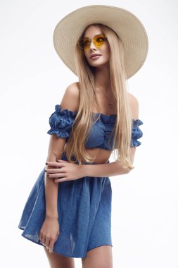 Mavi elbiseli ve geniş şapkalı güzel bir kadın model.