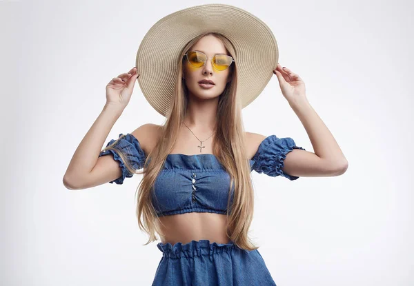 Mooi vrouwelijk model poseren in blauwe jurk en brede hoed — Stockfoto