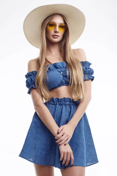 Mooi vrouwelijk model poseren in blauwe jurk en brede hoed — Stockfoto