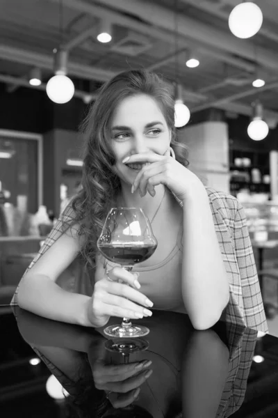 レストランのインテリアで赤ワインのガラスとエレガントな美しいブルネットの女性の肖像画 — ストック写真