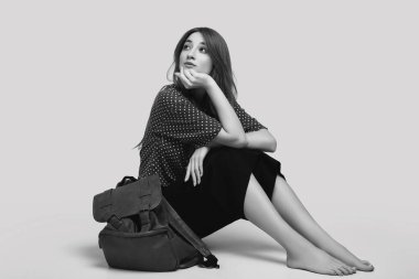 Sırt çantalı, seyahat etmeye hazır güzel bir kadının portresi. Gülümseyen öğrenci kız tatile çıkıyor. Gri arkaplanda izole.